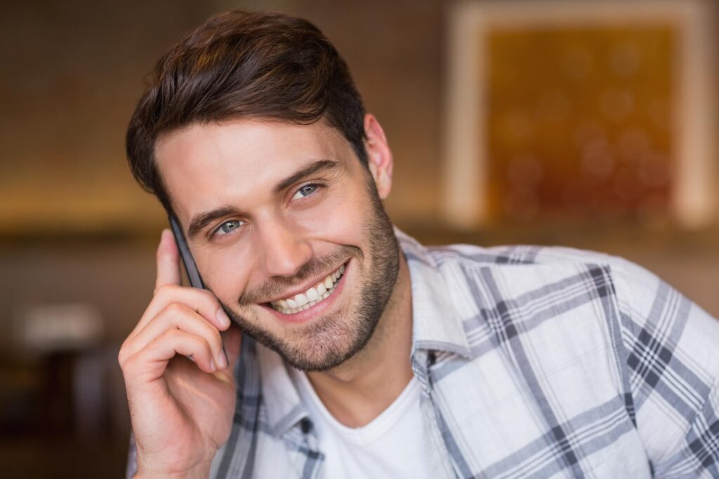 man smiling while he is on his phone